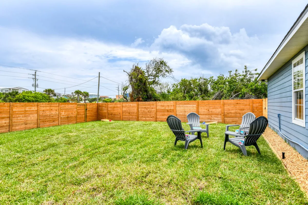 Fenced backyard with Adirondack chairs