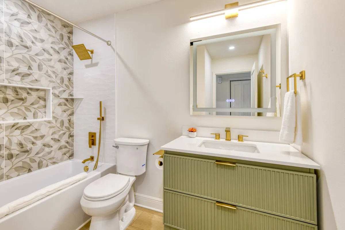 Bathroom with gold fixtures and green vanity