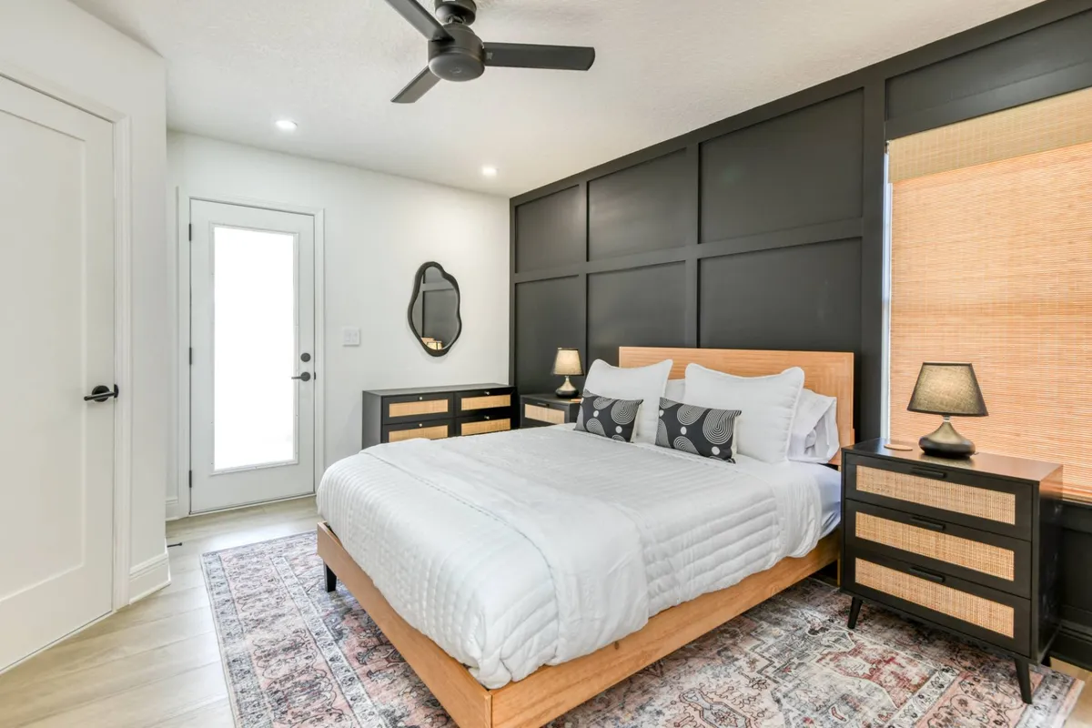 Primary bedroom with queen bed, smart TV and black accent wall